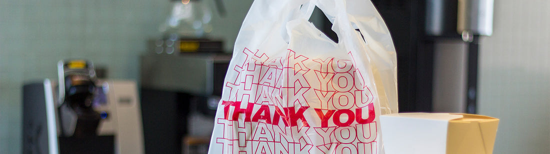 white plastic takeout bag with thank you printed on it in red