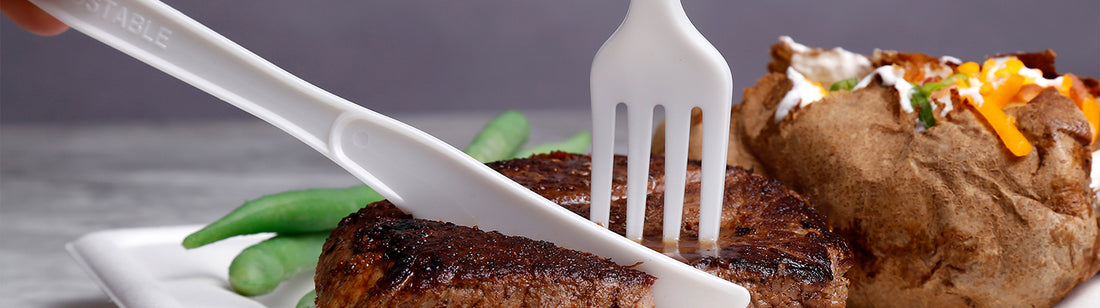 disposable PLA fork and knife cutting into meat