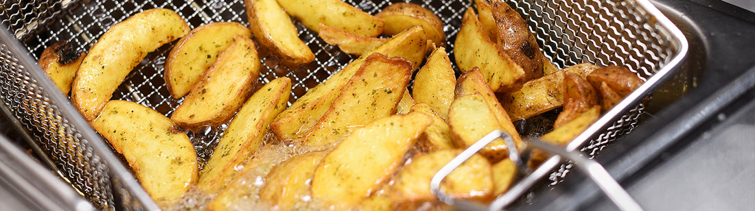 fresh potato wedges coming out of a fryer