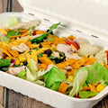 a classic taco salad in a 9" x 6" molded fiber container with the sauce on the side.