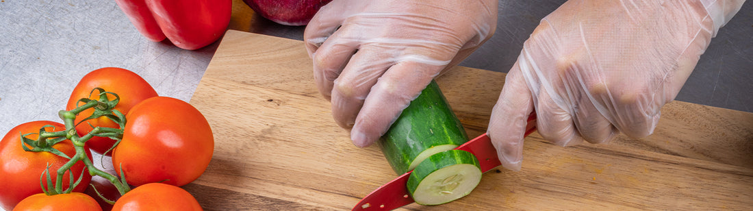 person chopping a cucumber on a wooden cutting board while wearing C2 Hybrid gloves