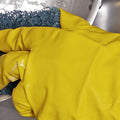 arm in a yellow latex glove washing a metal bowl