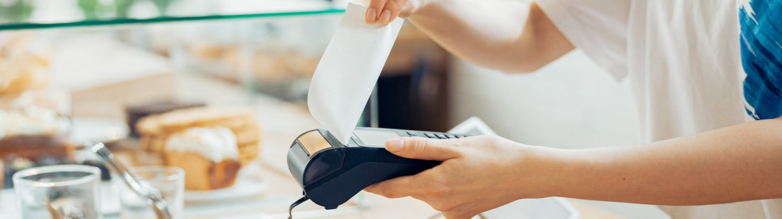 person holding a debit machine at a bakery