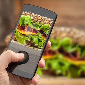 person taking a picture of a deli fresh sandwich with their phone