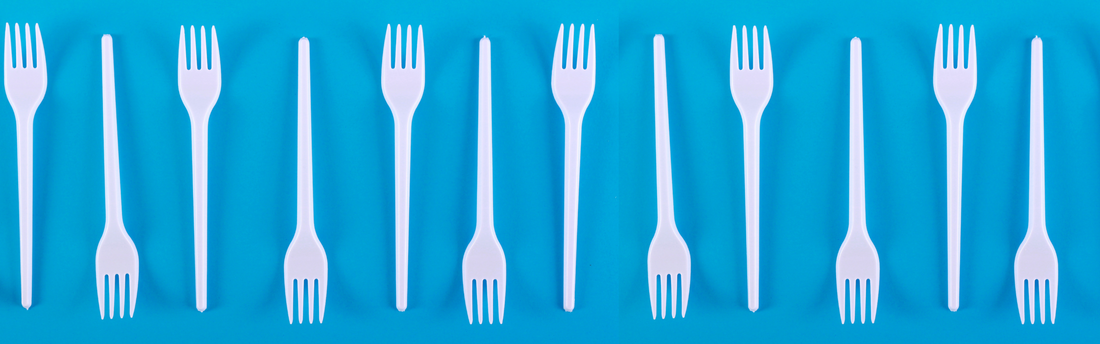 white plastic forks on a blue background