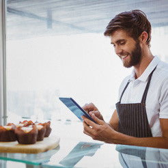 shop worker smiling at their smartphone