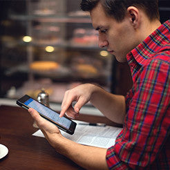 person wearing plaid and frowning at their phone