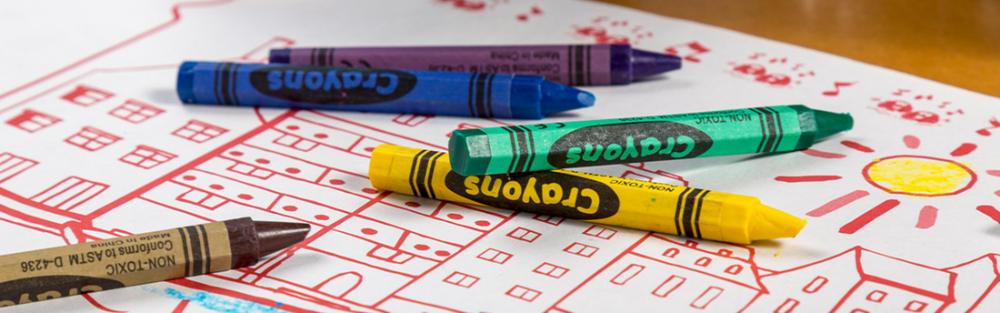 colorful crayons on top of kids drawing