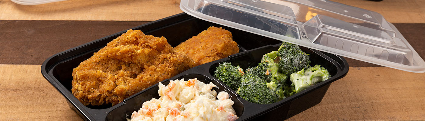3 compartment black plastic rectangular takeout container with chicken, broccoli and coleslaw