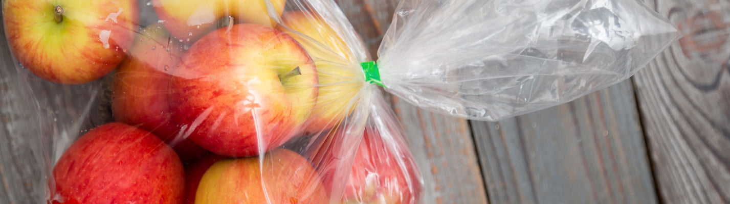 fresh apples in a clear food storage bag with a green tie