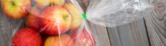 fresh apples in a clear food storage bag with a green tie