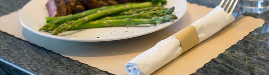 nice crisp asparagus on a glass plate on top of a tan paper placemat