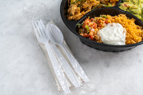 Mexican takeout with a white cutlery kit on the side