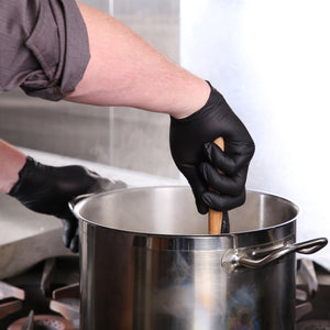 person wearing Powder-Free Black Nitrile Verge Gloves and stirring a large pot