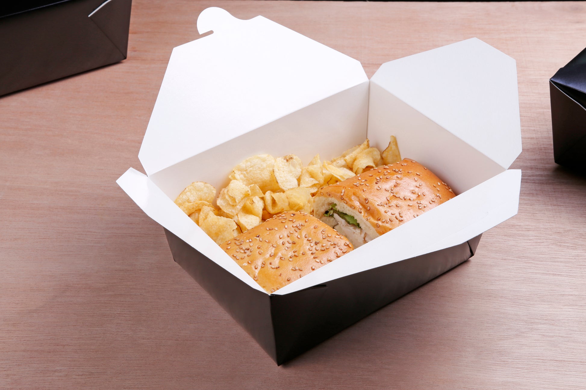 sub and potato chips in a 7-3/4" x 5.5" x 3.5" #4 Black Folded Takeout Box
