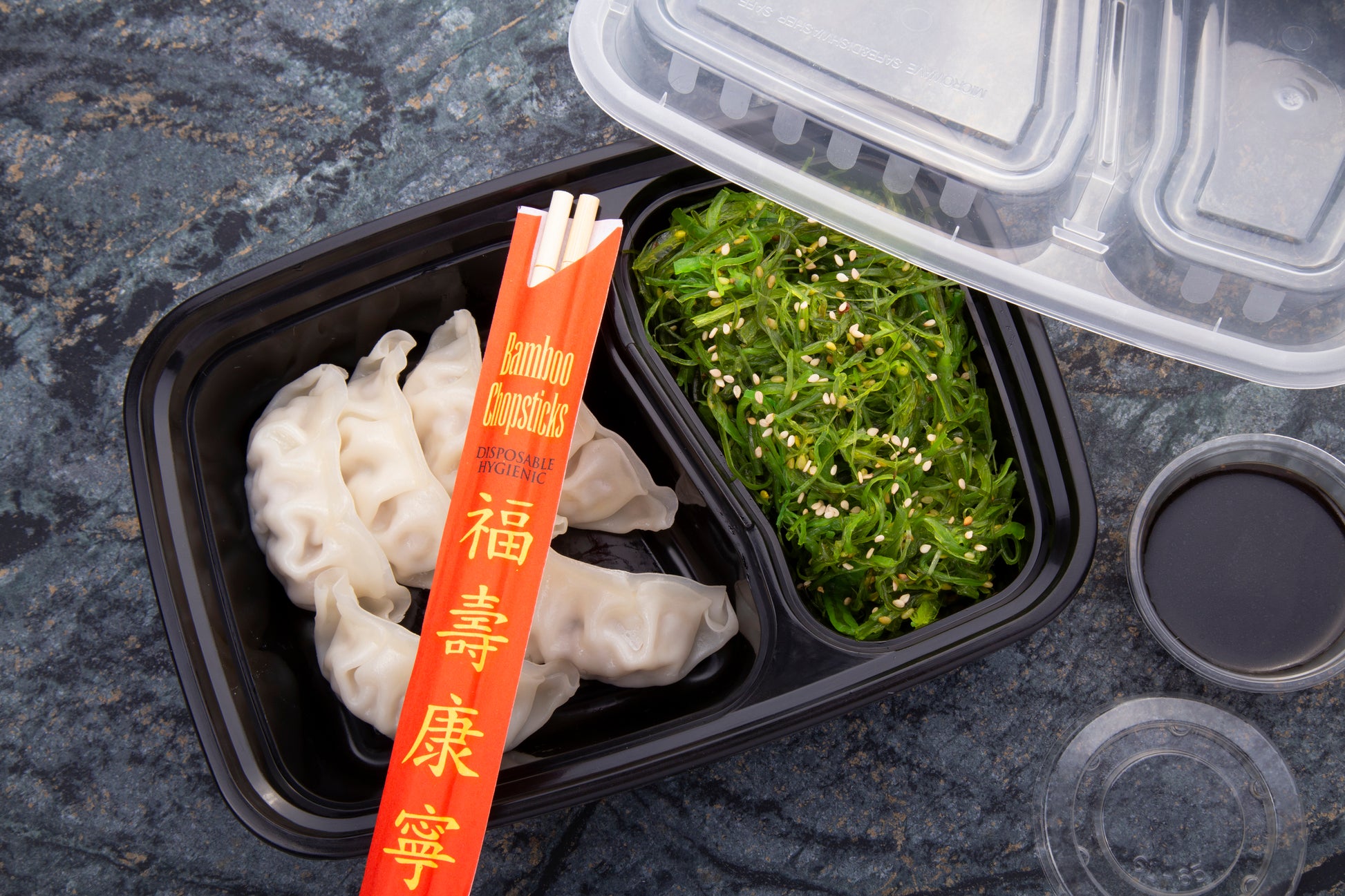 dumplings and nori takeout with Disposable Bamboo Chopsticks in a Red Sleeve on top