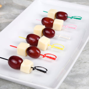 Cheese and grapes on multi-colored sword pics