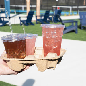 Person carrying drinks in a fiber tray. the drinks are in clear cups with clear compostable cellulosic straws