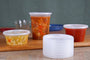 8-32 oz deli cup lid stack in front of the matching containers (sold separately) behind them